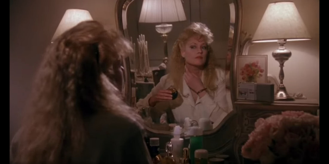 Кадр из фильма на котором Тесс пользуется духами Magie Noire Lancome, которые принадлежат Кэтрин.