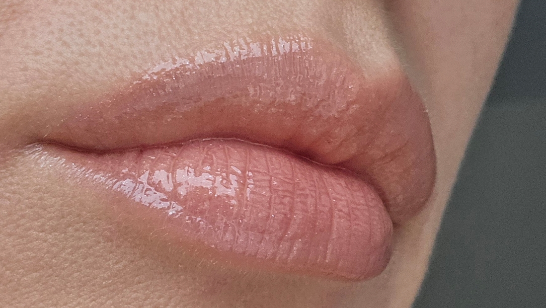 На губы нанесен карандаш и блеск