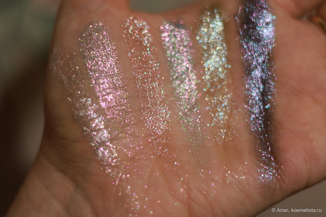 Свотчи сверкающих оттенков в расфокусе под электрическим светом (слева направо): Arctic Wolf - Alpha Moon - Majestic Moon - Winter Howl - Moonlight Prowl - Nightfall